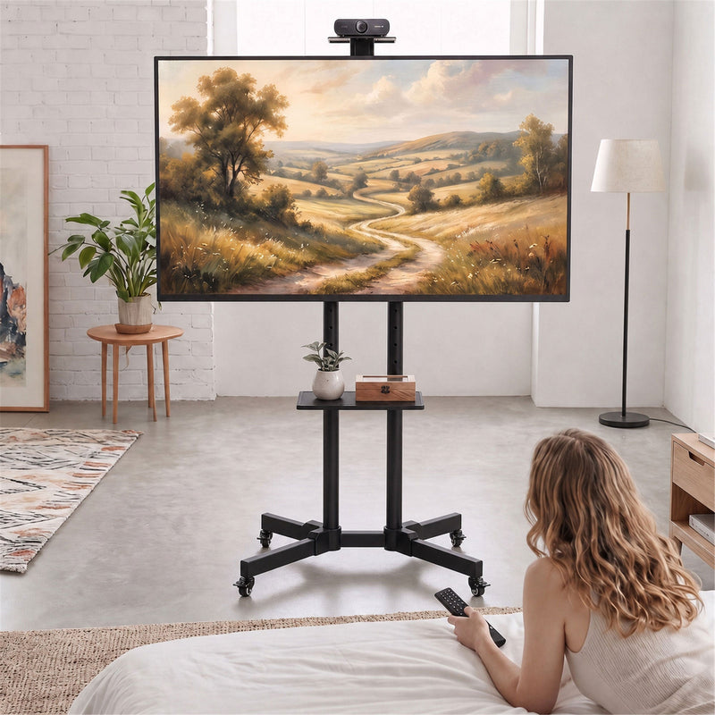 Lifestyle photo of the mobile TV stand in a bedroom with a webcam mounted above the screen