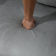Close-up of sponge padding, armrest, pillow and suede fabric on light grey chair bed