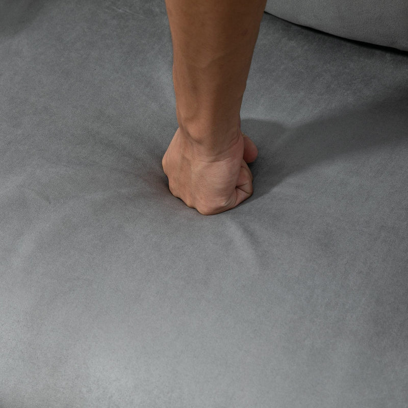 Close-up of sponge padding, armrest, pillow and suede fabric on light grey chair bed