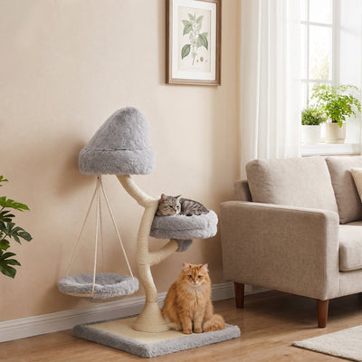 Cat resting on the side bed of the light grey cat tree while a ginger cat sits by the base next to a sofa