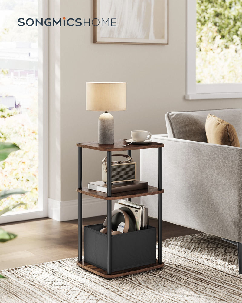 Ebony Walnut side table styled next to a sofa with a lamp, books and headphones in the basket