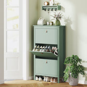 Green shoe cabinet in an entryway with a wall shelf and shoes stored inside