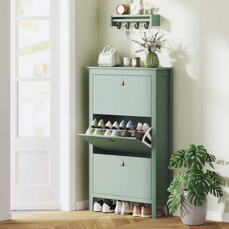 Green shoe cabinet in an entryway with a wall shelf and shoes stored inside