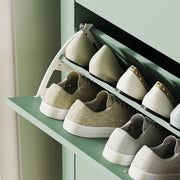 Close-up of shoes arranged on the cabinet's open drawer shelf