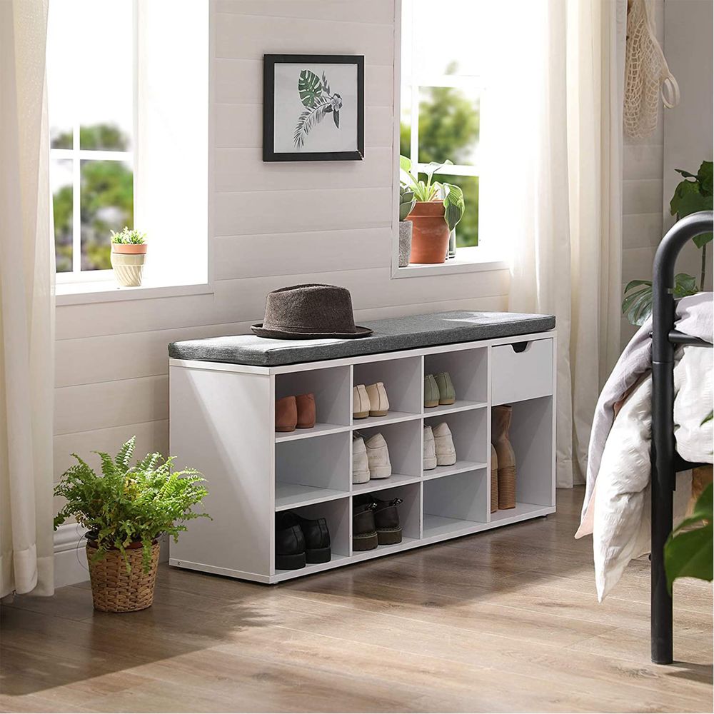 modern white shoe storage bench with dark grey cushion in a bedroom setting