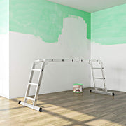 Ladder used as a bridge indoors beside a paint tin while a ceiling is decorated
