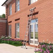 Ladder extended straight and leaning against the brick wall of a house