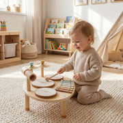 Toddler playing the wooden musical instrument set on a rug in a playroom