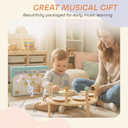 Gift box packaging for the musical instrument set beside a mother and toddler