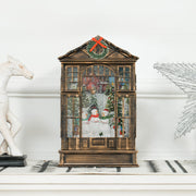 Snow globe lantern on a white shelf beside a white horse ornament