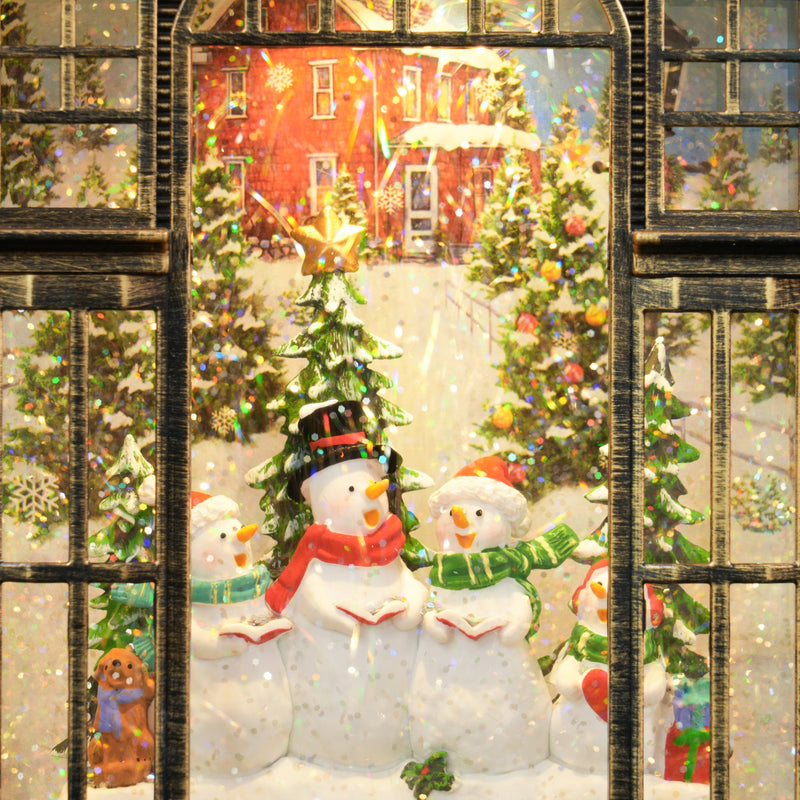 Close-up of three snowmen and Christmas trees in the snowy village scene