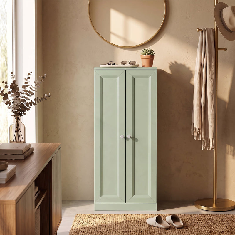 Light green bathroom cabinet used as hallway storage beside a console table and coat stand