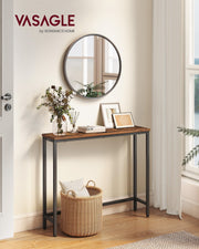 Rustic brown narrow console table in a hallway beneath a round mirror with a woven basket underneath