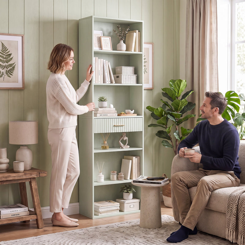 Light green bookcase in a living room with a couple relaxing nearby