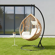 Natural rattan effect hanging chair with cream cushion styled in a living room
