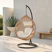 Natural rattan hanging chair shown in an outdoor patio setting