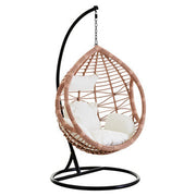 Natural rattan effect hanging chair with cream cushion, plain background
