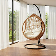 Natural rattan hanging chair styled in a sunroom setting