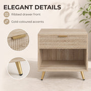 Close-up of the ribbed drawer front and gold-tone handle and leg on the natural wood bedside table