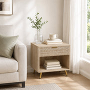 Natural wood bedside table styled in a living room beside a sofa with a plant