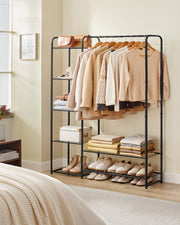 Ink black open wardrobe styled in a bedroom with hanging clothes and folded storage