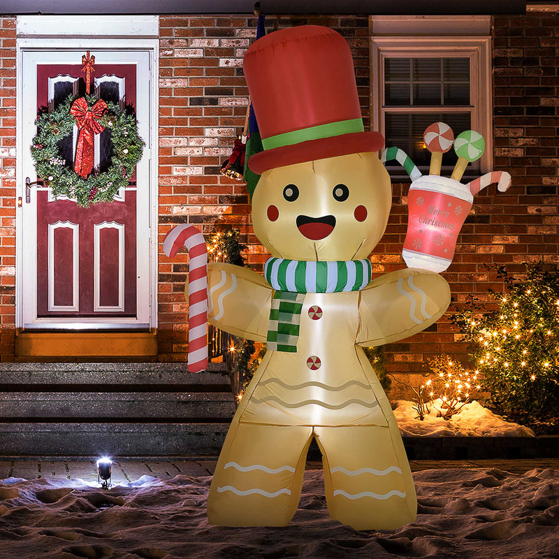Lit inflatable gingerbread man beside a front door with a Christmas wreath