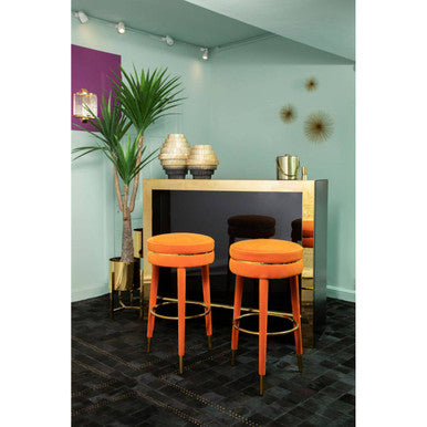 Orange velvet bar stool in a home bar setting