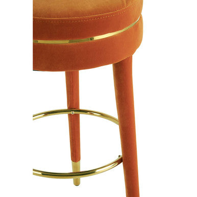 Close-up of velvet-covered leg and gold finish footrest on bar stool