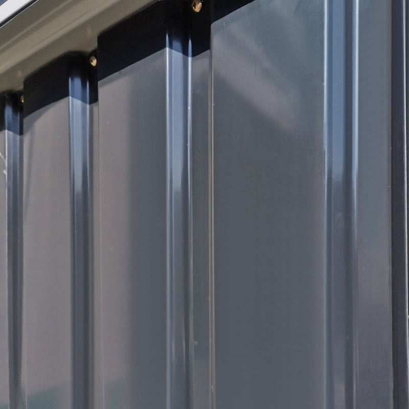 Close-up of dark grey corrugated wall panels and the roof edge