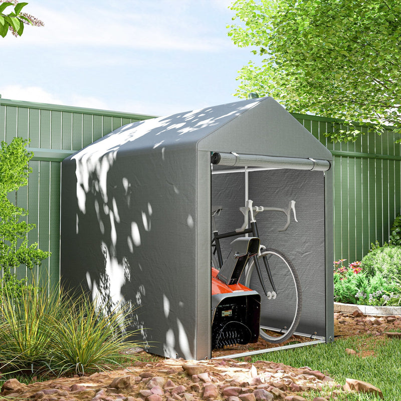 Light grey storage shed tent set up beside a green garden fence with a bicycle stored inside