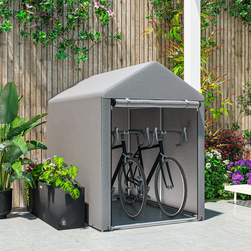 Light grey shed tent on a patio storing two bicycles in front of a wooden fence