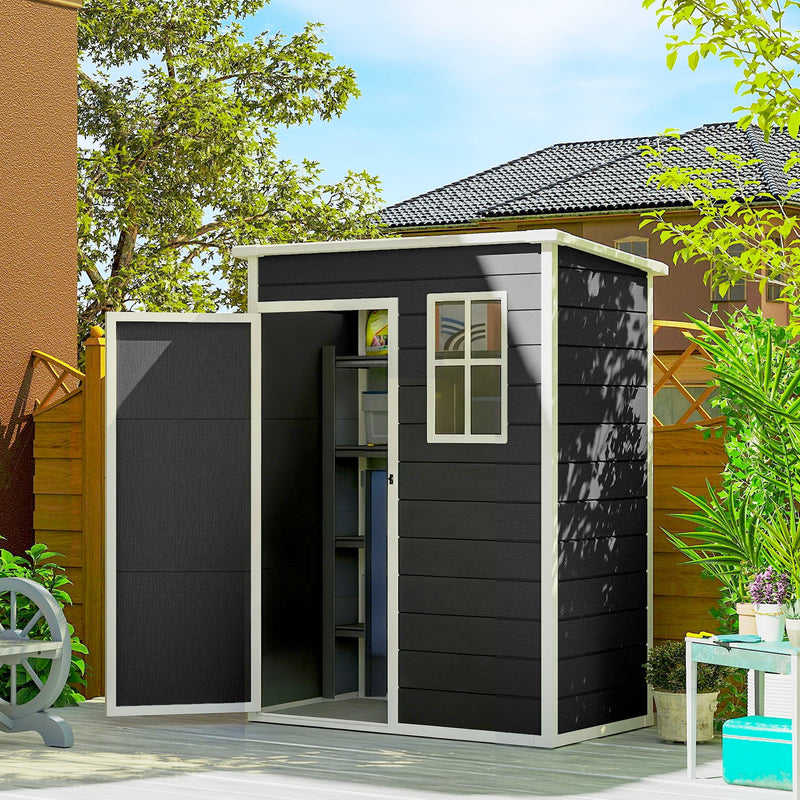 The black plastic shed in a garden with its door open, showing shelves and stored items inside