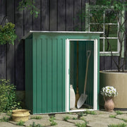 Green shed set against a dark timber house wall with a spade leaning beside the door