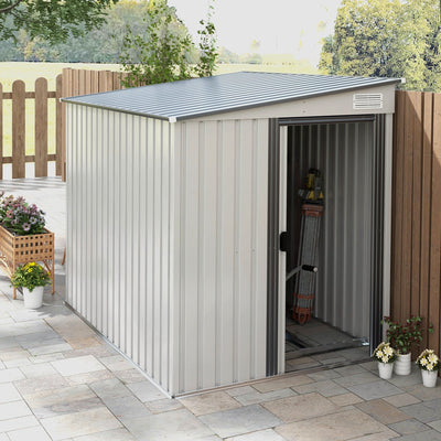 The white lean-to shed on a paved patio with the door slid open, showing tools stored inside