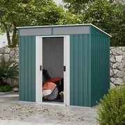 Green metal shed on a patio with its sliding doors open and a mower stored inside