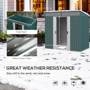 Green metal shed standing in snow, with the sloped roof and steel frame shown