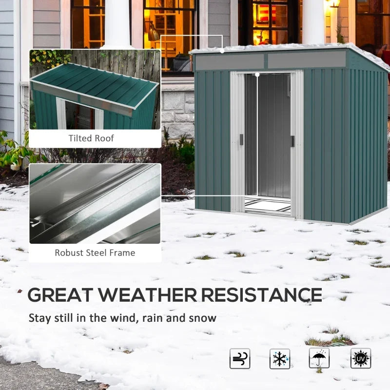 Green metal shed standing in snow, with the sloped roof and steel frame shown
