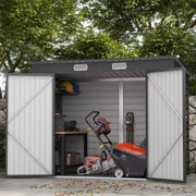Dark grey shed in a garden with doors open on a workbench, chainsaw and hand tools