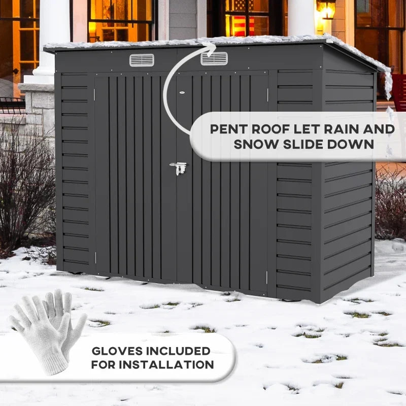 Dark grey shed standing in snow, captioned pent roof lets rain and snow slide down