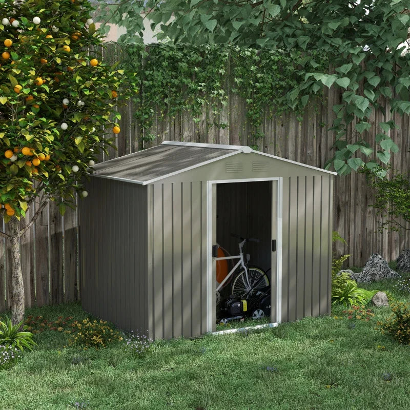 Shed on grass with one sliding door open showing a bike and mower stored inside