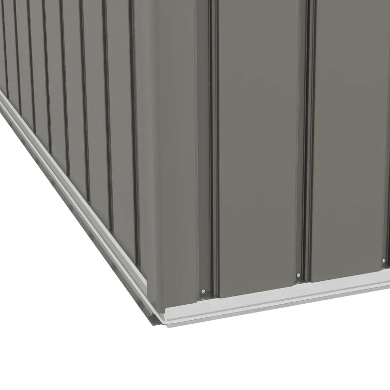 Close-up of the shed base rail and ribbed grey wall panels at the corner