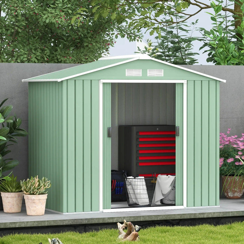 Light green apex metal shed in a garden with a red tool chest stored inside