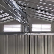 Inside the shed looking up at the apex roof frame and 2 white louvre vents set into the gable