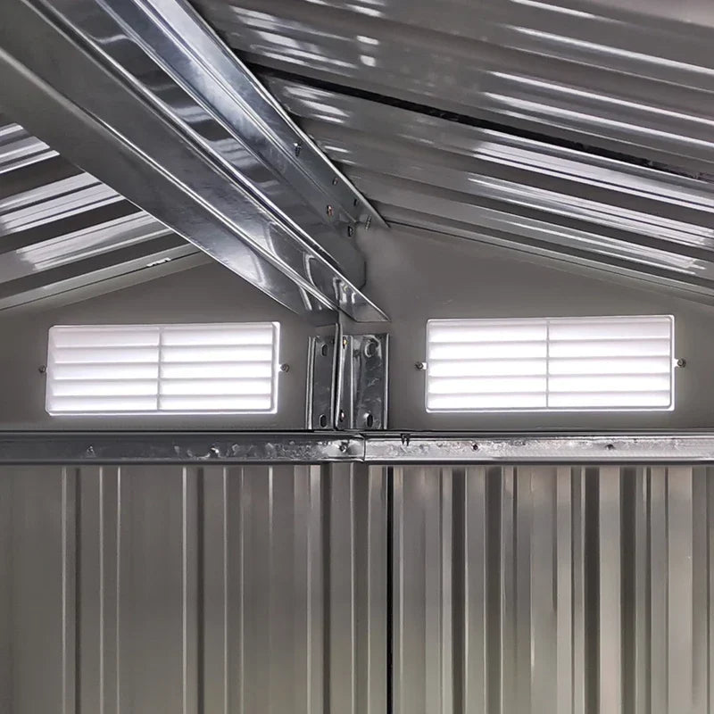 Inside the shed looking up at the apex roof frame and 2 white louvre vents set into the gable