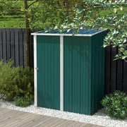 Dark green pent roof metal shed on decking in front of a dark painted fence and flowering shrubs