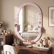 Oval pegboard mirror above a dressing table with make-up and a chair