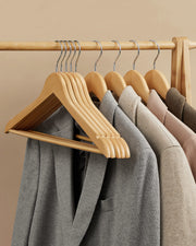 Wooden hangers holding jackets and coats on a wardrobe rail