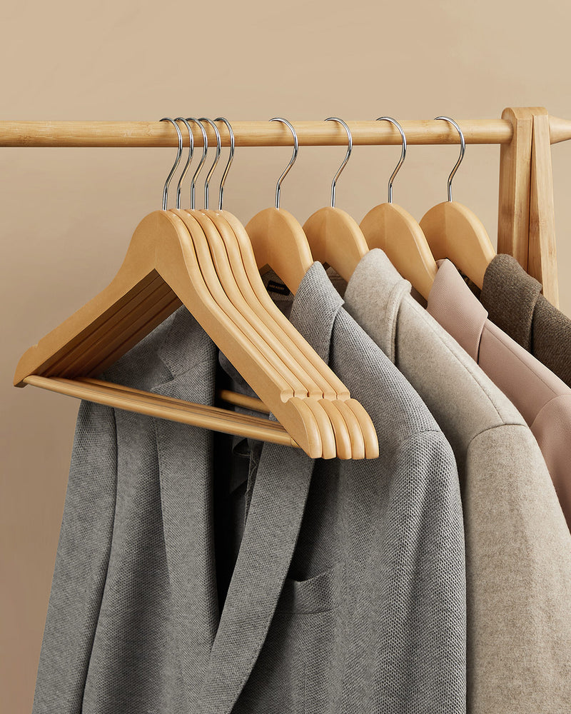 Wooden hangers holding jackets and coats on a wardrobe rail