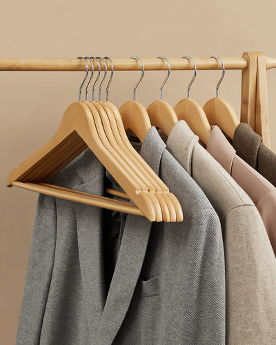Wooden hangers holding jackets and coats on a wardrobe rail