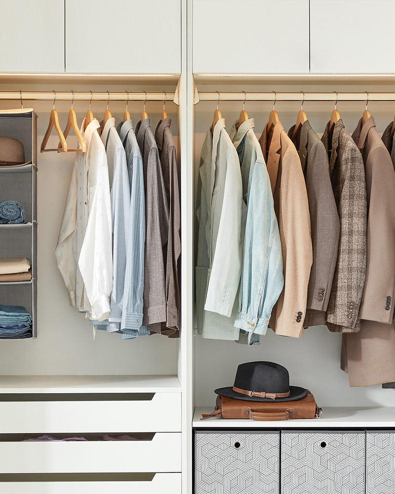 Wardrobe interior with shirts and jackets hanging on matching wooden hangers